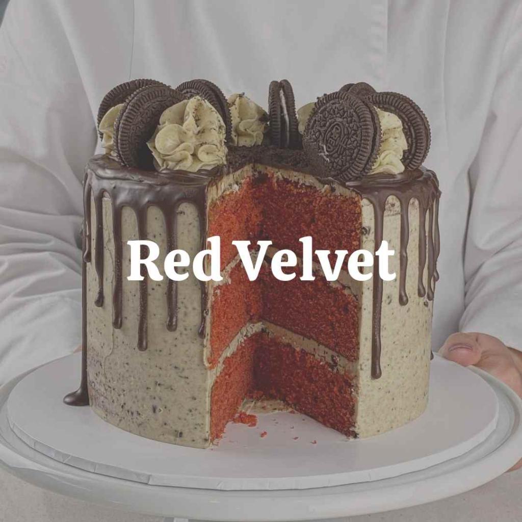 A close-up image of a slice of red velvet cake topped with buttercream